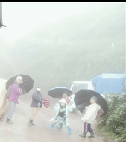 Parents, students, and community members in Pugo, Buguias, Benguet brave heavy rains and fog with umbrellas and rain gear, embodying the…